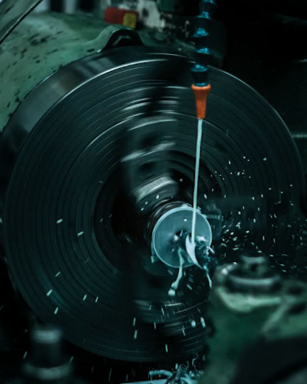 A machine spraying metal working fluid across a flat surface